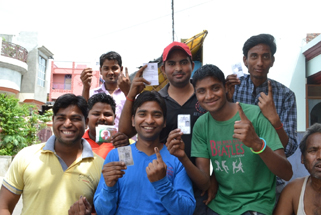 मतदान के बाद वोटर आईडी कार्ड दिखाते युवा मतदाता